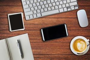 top visie kantoor tafel met kladblok, computer en koffie kop en computer muis en kader foto. visie van bovenstaand met kopiëren ruimte. foto