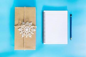 top visie bruin geschenk doos en notitieboekje papier voor nieuw jaar Aan blauw pastel kleur. foto