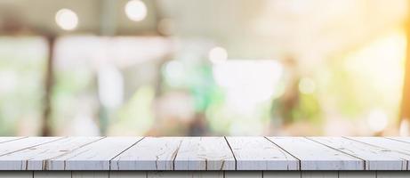 leeg hout tafel en wazig licht tafel in koffie winkel en cafe met bokeh achtergrond. Product Scherm sjabloon. foto