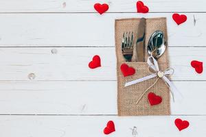 bovenstaand hout tafel reeks zilverwerk en rood hart voor Valentijn dag met ruimte. foto