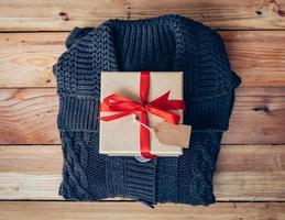 geschenk doos en kleding Aan hout achtergrond voor Kerstmis geschenk. foto