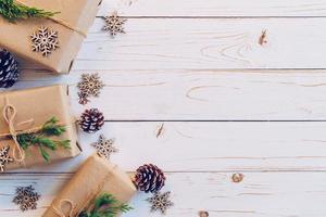 eigengemaakt verpakt Kerstmis geschenk doos presenteert Aan een hout tafel achtergrond. foto