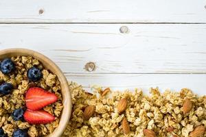 eigengemaakt muesli en vers bessen Aan hout tafel met ruimte met ruimte. foto