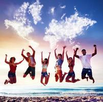 gelukkig glimlachen vrienden jumping over- een blauw lucht met een wereld kaart gemaakt van wolken foto