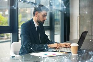 bedrijf Mens werken met laptop Aan de bureau in een modern kantoor in de buurt venster. netwerk Effecten foto