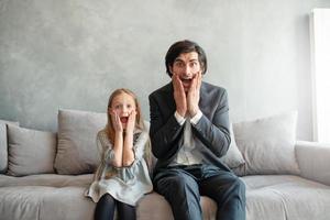 vader en dochter kijken beide geschokt iets foto