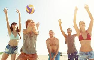 groep van vrienden spelen Bij strand volley Bij de strand foto