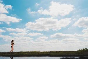 rennen meisje Aan een groen veld- en helder lucht foto