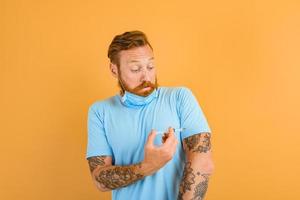 bang Mens met baard, tatoeëren en masker voor covid-19 is klaar voor de virus vaccin foto