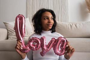 valentijnsdag dag portret van Afrikaanse vrouw met liefde vormig ballon. 14 februari concept foto