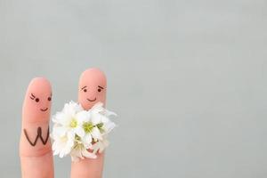 vingers kunst van gelukkig paar. Mens is geven bloemen naar vrouw. foto