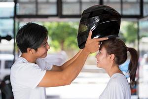 reizend paar permanent en het dragen van een motorhelm foto