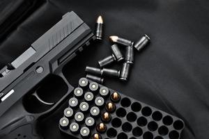 automatisch zwart 9 mm pistool en kogels Aan zwart leer achtergrond, selectief en zacht focus, kopiëren ruimte. foto