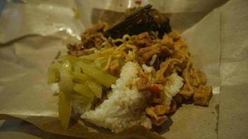 nasi kucing speciaal, kat rijst- speciaal met opor hati sapi Aan een papier inpakken foto