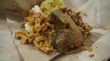 nasi kucing speciaal, kat rijst- speciaal met opor hati sapi Aan een papier inpakken foto