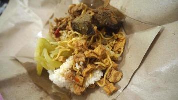 nasi kucing speciaal, kat rijst- speciaal met opor hati sapi Aan een papier inpakken foto