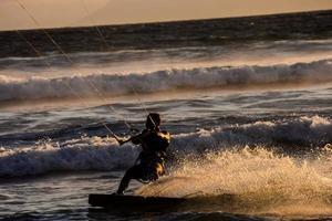 vlieger surfer Bij zonsondergang foto