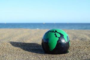 wereldbol in de zand foto