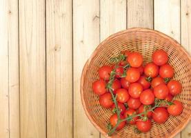 tomaten in een rieten mand op een houten tafel achtergrond