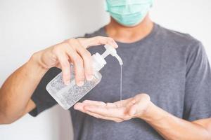 man handen met behulp van handdesinfecterende gel dispenser tegen nieuw coronavirus of covid-19, hygiëne en gezondheidszorg concept foto