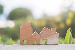 houten huismodel op het grond-, huisvestings- en onroerendgoedconcept foto