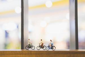 miniatuurreizigers met fietsen op een houten brug foto