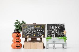 miniatuurmensen die halloween-decoraties van de partijsteun op een witte achtergrond, halloween-partijconcept kleuren foto