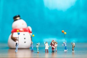 miniatuur gelukkige familie die kerstmis, kerstmis en gelukkig nieuwjaarconcept viert foto