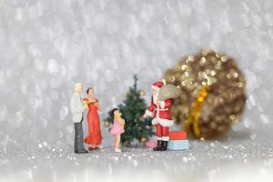 miniatuur gelukkige familie die kerstmis, kerstmis en gelukkig nieuwjaarconcept viert foto