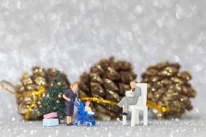 miniatuur gelukkige familie die kerstmis, kerstmis en gelukkig nieuwjaarconcept viert foto