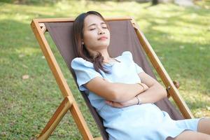gelukkig Aziatisch vrouw Aan camping stoel foto
