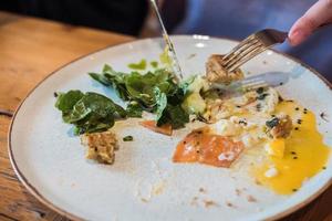 restjes van een hartelijk avondeten van ei, rood vis, avocado en Groenen in een restaurant foto