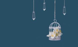 decoratieve kooi met jasmijnbloemen en glazen hangers aan kettingen op een turquoise achtergrond. mooi feestelijk huwelijksconcept foto