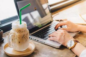 bijgesneden schot visie van zakenvrouw gebruik makend van haar laptop in cafetaria. foto