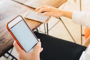 zakenvrouw gebruik makend van haar mobiel telefoon in cafetaria. foto