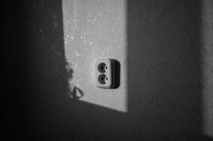 een dubbele stopcontact Aan een pale oranje muur. macht levering. foto