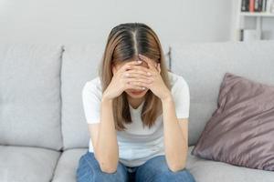 depressie en mentaal ziekte. Aziatisch vrouw teleurgesteld, verdrietig na ontvangen slecht nieuws. benadrukt meisje verward met ongelukkig problemen, ruzie maken met vriend, huilen en zich zorgen maken over niet verwacht zwangerschap. foto