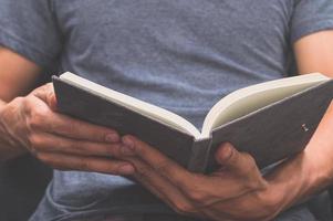 man leest een boek in zijn handen foto