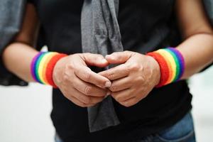 aziatische vrouw met regenboogvlag, lgbt-symboolrechten en gendergelijkheid, lgbt-trotsmaand in juni. foto