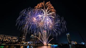 vuurwerk op de rivier in de donkere lucht foto