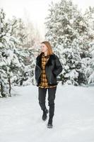 jong mooi vrouw met kort haar, in geruit overhemd wandelen in besneeuwd Woud. winter vakantie foto