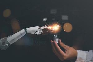 oplossing concept en demonstreren leiderschap strategieën ,Dat lood de bedrijf in een geslaagd richting ,met innovatie en hersenen macht van brainstorming ,licht lamp in menselijk hand- en robot hand- foto