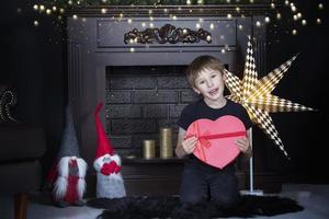 gelukkig weinig jongen Bij huis met een Kerstmis Geschenk. foto