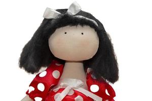 pop gemaakt van handgemaakt stoffen. portret van een pop in een rood jurk met polka stippen, enkel en alleen ogen zijn geschilderd Aan haar gezicht. foto