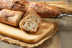 huis gemaakt gesneden baguette brood Aan hout achtergrond, brood en bakkerij foto