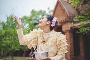 portret mooi vrouw in songkran festival met Thais traditioneel kostuum foto