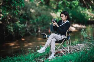 jong mooi vrouw gebruik camera nemen foto in natuur park