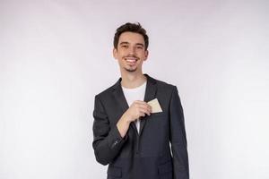 portret van jong glimlachen knap zakenman tonen credit kaart geïsoleerd over- wit achtergrond foto