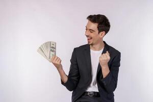 portret van een vrolijk Mens Holding dollar rekeningen en aan het doen winnaar gebaar balanceren vuist over- wit achtergrond foto