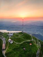 een transmissie toren Aan een berg gedurende de zonsondergang foto